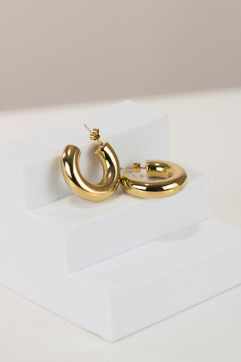 Aros de oro sobre soporte blanco
