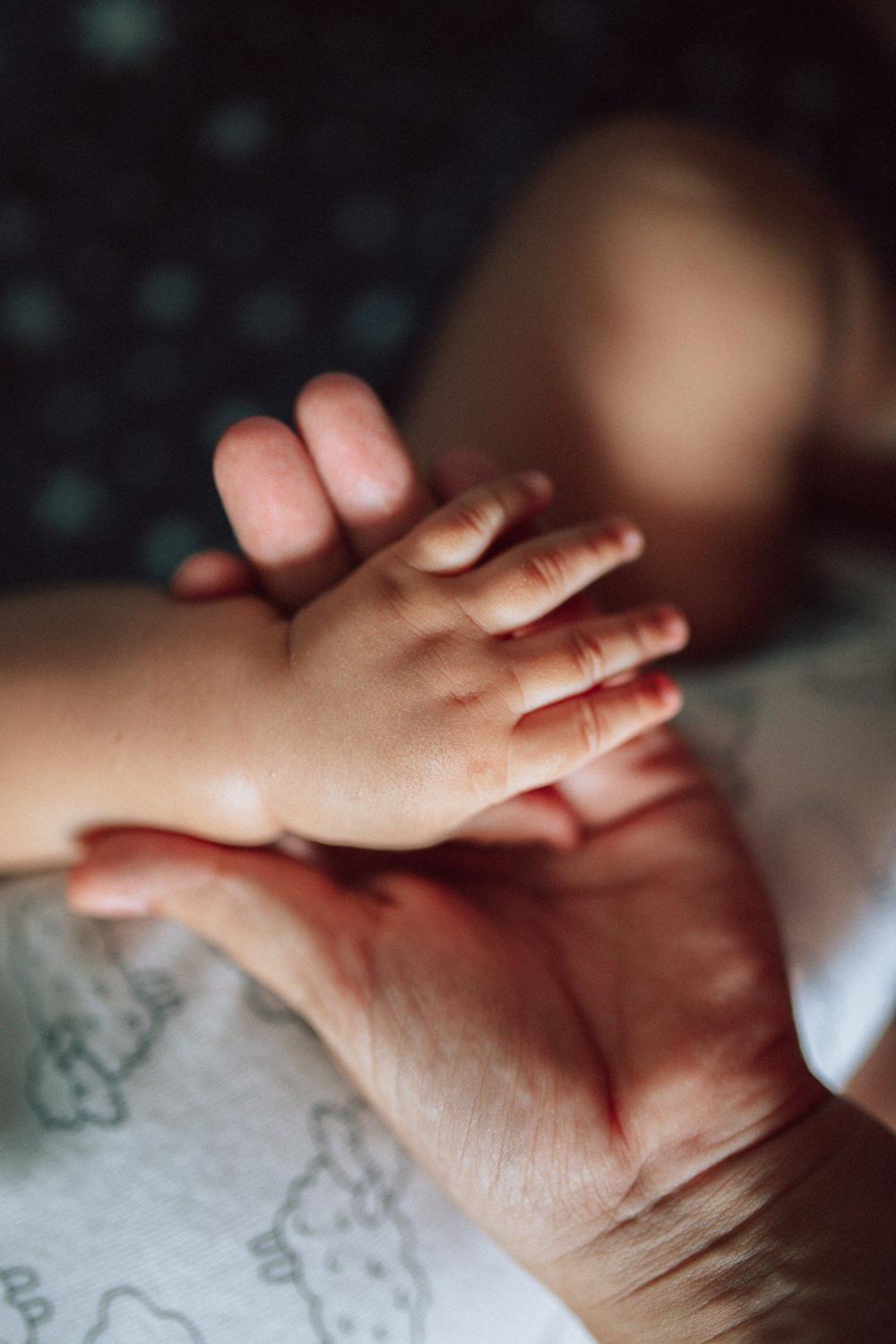 Mano de bebé sobre la mano de su madre